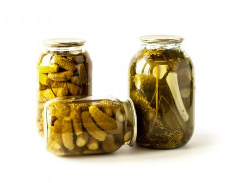 Salted cucumbers in glass jars isolated on white