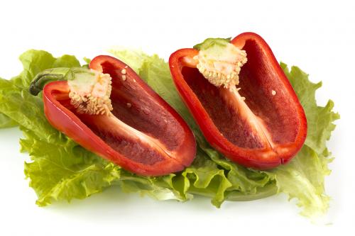 Cutted sweet red pepper on salad leaves