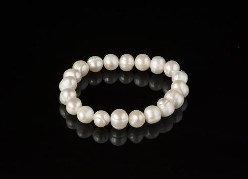 Pearl bracelet on a black mirror surface