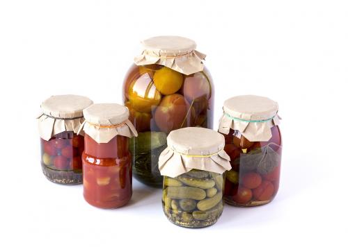 Salted tomatoes, cucumbers and lecho in a glass banks isolated o