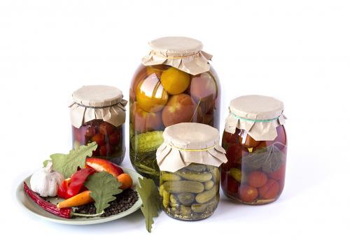 Salted tomatoes and cucumbers in a glass banks with spices isola