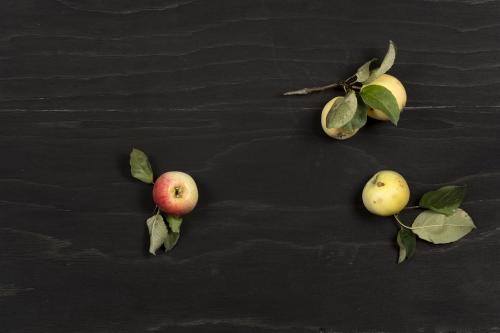 Small apples on a black wooden surface