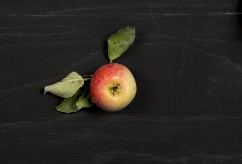 Fresh apple on a black wooden surface