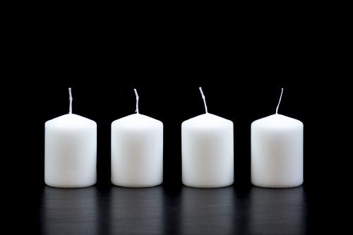 White candles on black background
