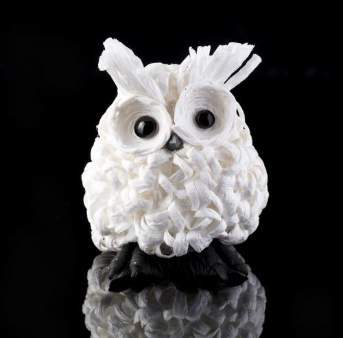 White toy owl on black mirror background