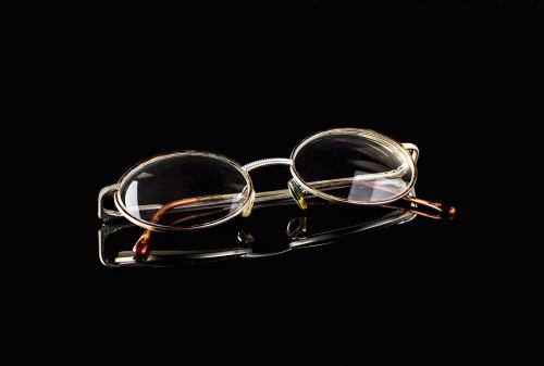 Retro reading glasses on black mirror background