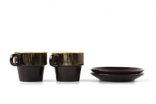 Two ceramic cups with dishes isolated on white