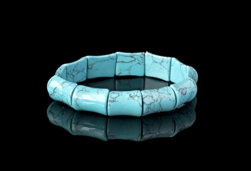 Turquoise bracelet on a black mirror surface