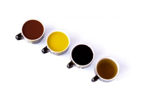 Four different juices in ceramic cups isolated on white