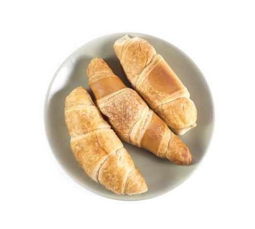 Fresh croissants on green plate isolated on white