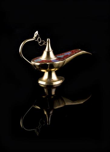 Moroccan brass oil lamp on black mirror background