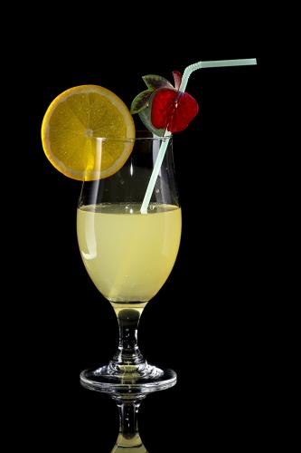 Glass of lemonade with bendie on black mirror background