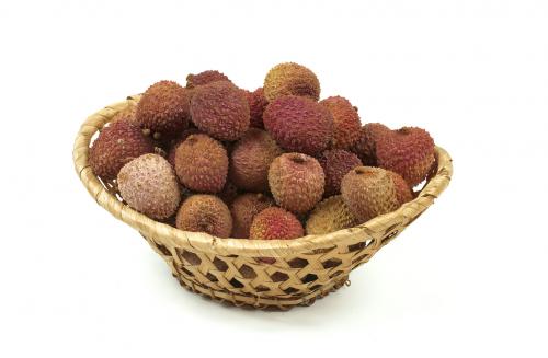 Some lychee in a fruit basket isolated on  white